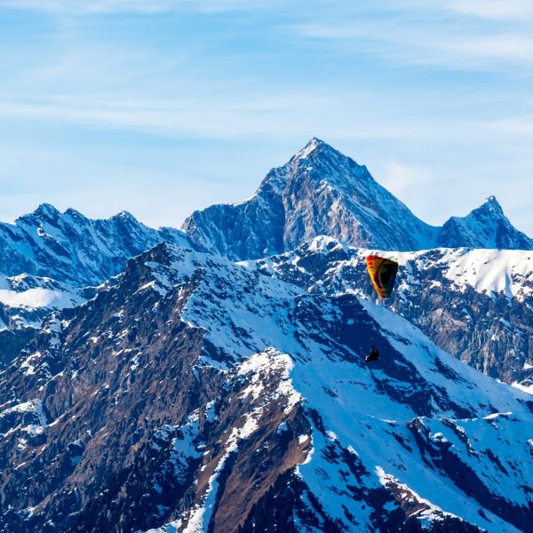 A beautiful landscape of snowcovered mountains with a paraglider in  South Tyrol, Dolomites, Italy